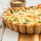 Whole gluten-free quiche in a fluted tart pan on a table