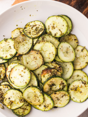Blackstone griddle zucchini golden and charred with grill marks on white serving plate