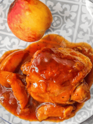 Air fryer peach chicken thighs served on a plate with caramelized peaches and herbs.