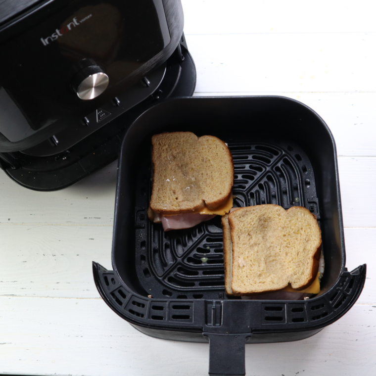 Placing the Monte Cristo Sandwich into the air fryer basket. 