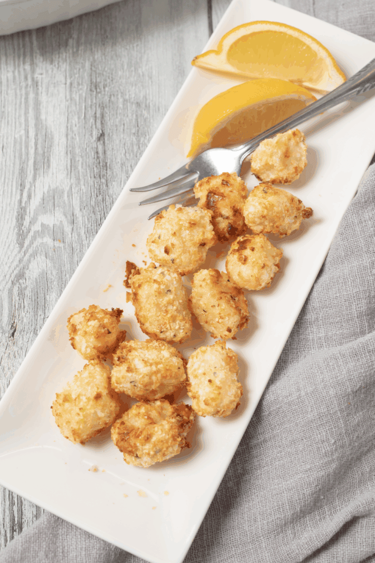 Plate of golden air fryer scallops coated with crushed Ritz crackers, ready to serve
