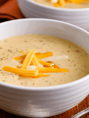 Bowl of creamy Copycat Outback Steakhouse Walkabout Soup topped with shredded cheese and chopped parsley.