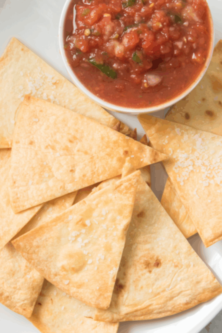 Air fryer basket filled with crispy homemade Chili’s-style tortilla chips.