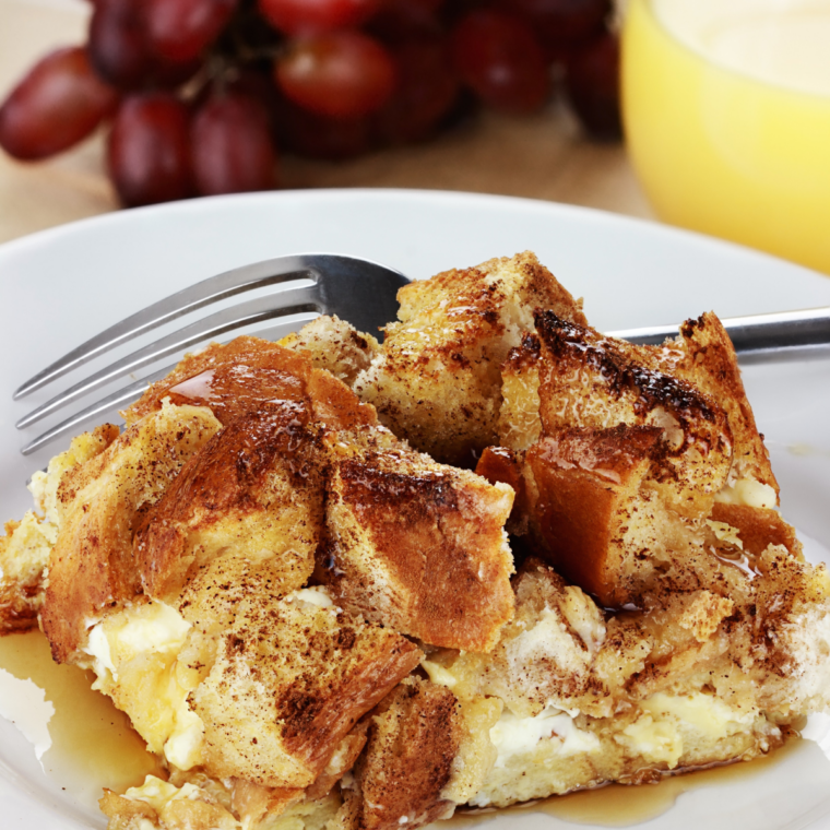 What to serve with French toast — maple syrup poured over a stack of thick-cut French toast with butter and fresh berries