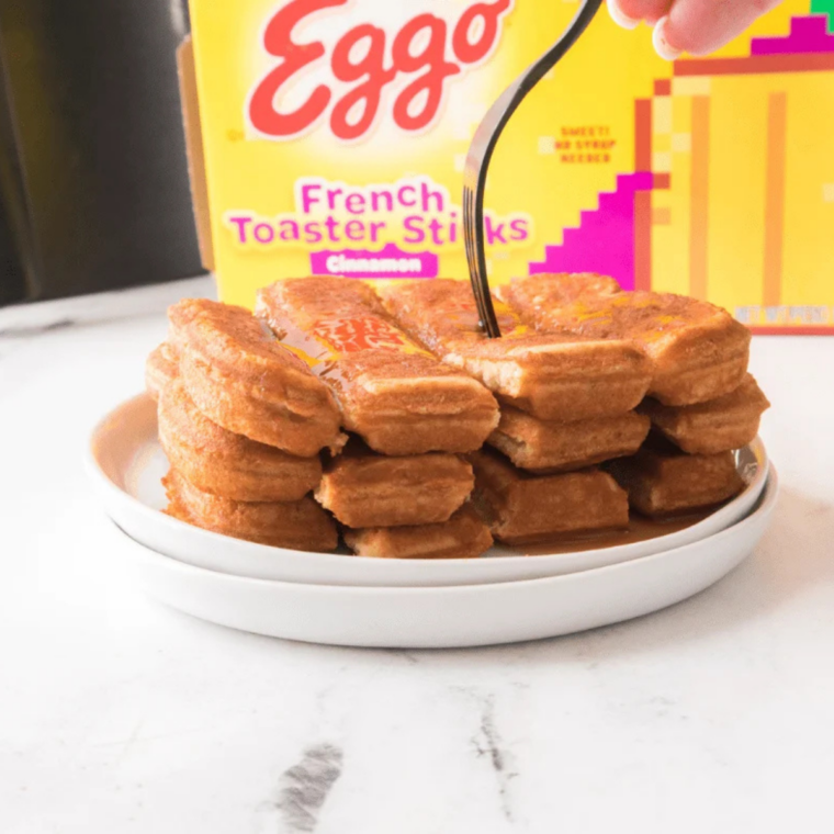 What to serve with French toast — French toast sticks stacked on a plate with a bowl of maple syrup for dipping