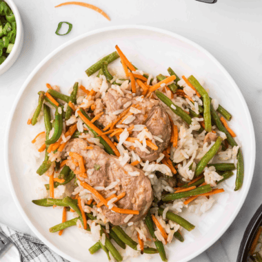 Crispy General Tso's pork with green beans over white rice in a bowl
