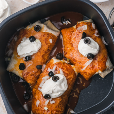 Golden crisp Enchiritos in an air fryer basket after cooking, before the red sauce and cheese are added