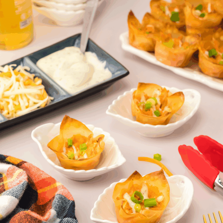 Plate of golden, crispy buffalo chicken rangoons filled with creamy buffalo chicken and cheddar, served with ranch dressing for dipping.
