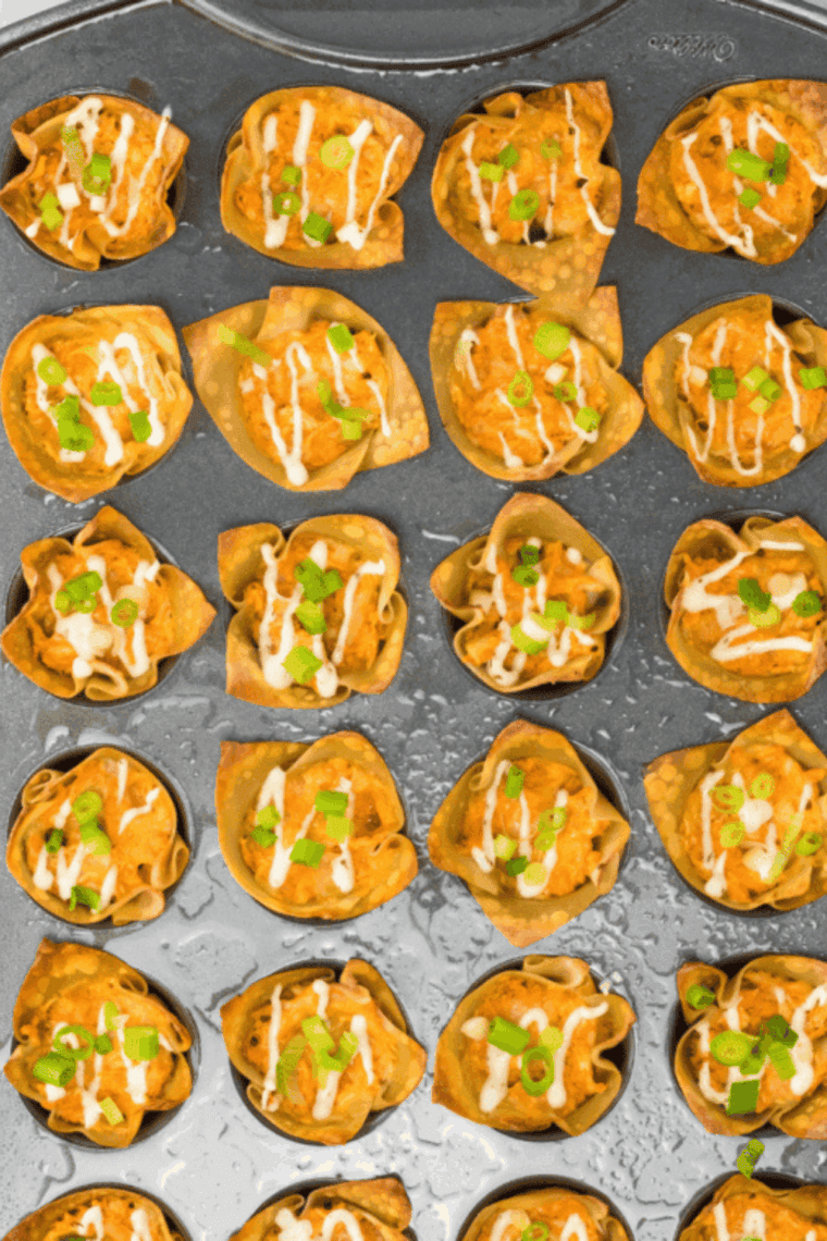 Golden, crispy buffalo chicken rangoons served on a plate with ranch and buffalo sauce for dipping, ready to enjoy.
