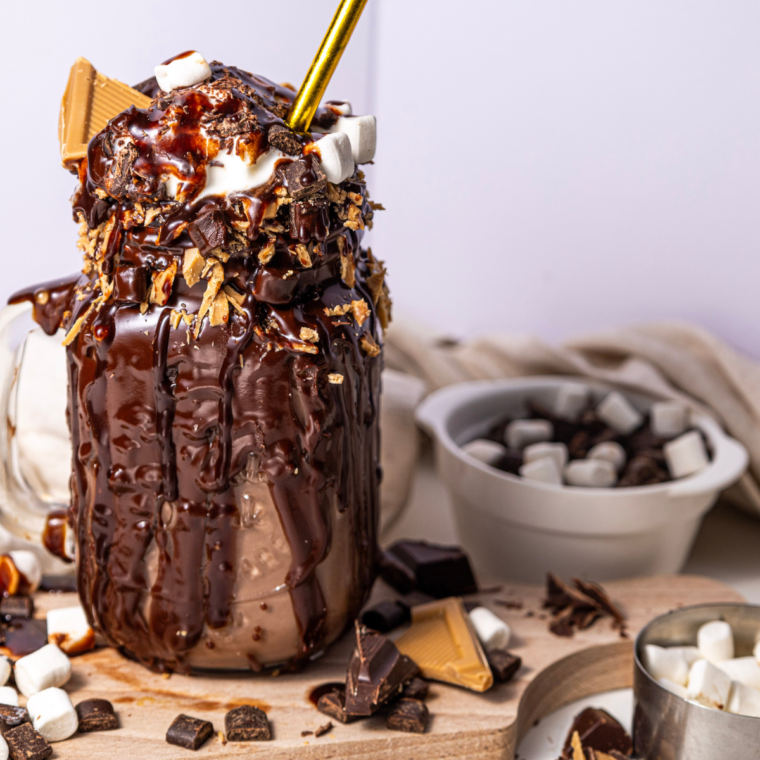 Ninja Creami Freakshake topped with whipped cream, chocolate syrup, colorful sprinkles, and candy, making for an eye-catching and tasty dessert.