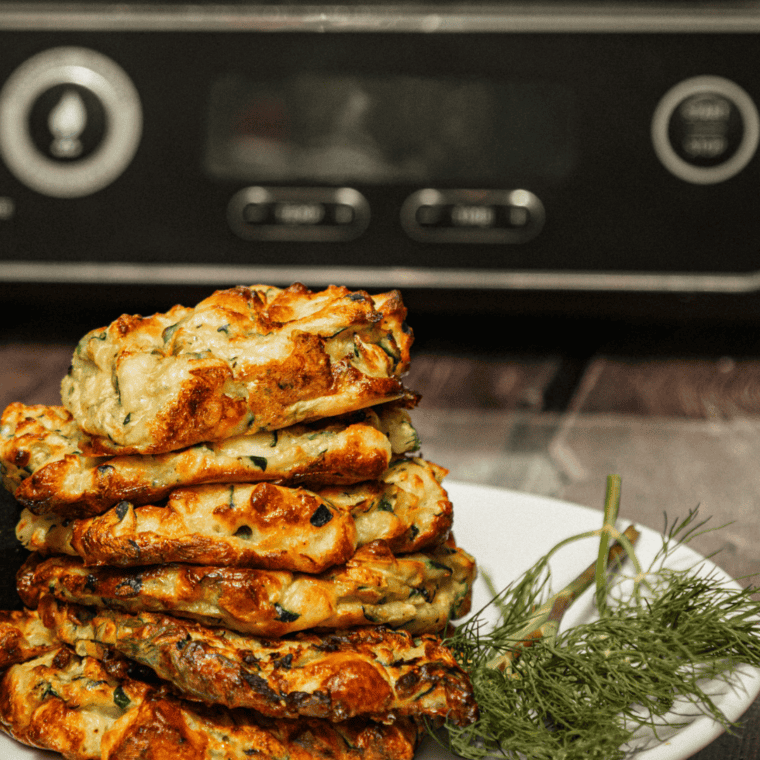 "Freshly cooked Ninja Foodi Woodfire Zucchini Fritters cooling on a wire rack."