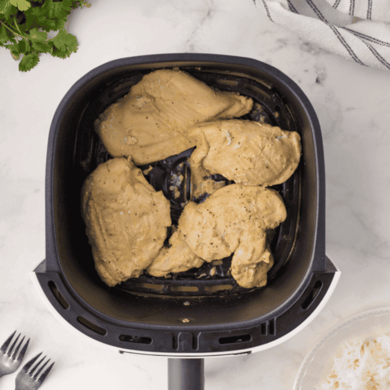 Cooked Thai Coconut Lime Chicken Cheesecake Factory in the air fryer basket.