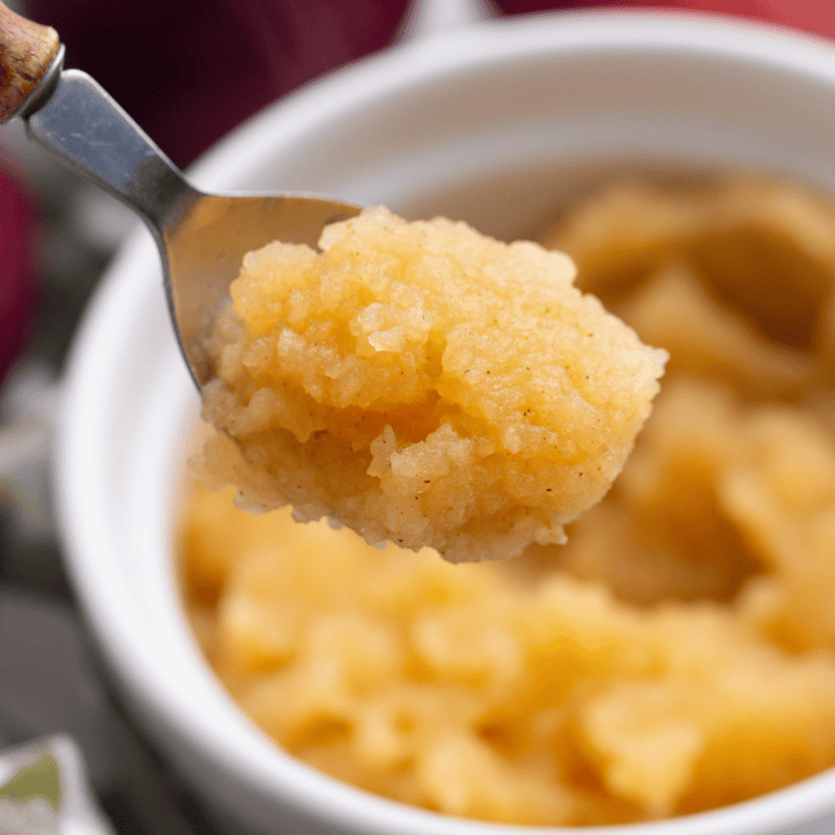 Freshly made Air Fryer Applesauce served in a white bowl, topped with a sprinkle of cinnamon.