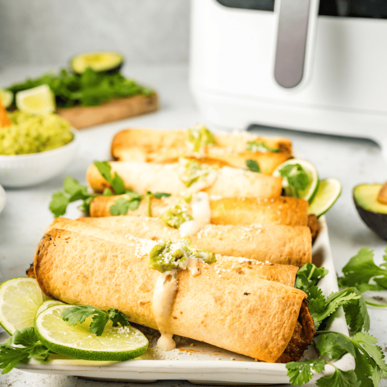 Air-fried pulled pork taquitos with a crispy golden exterior, filled with tender pulled pork for a flavorful bite.