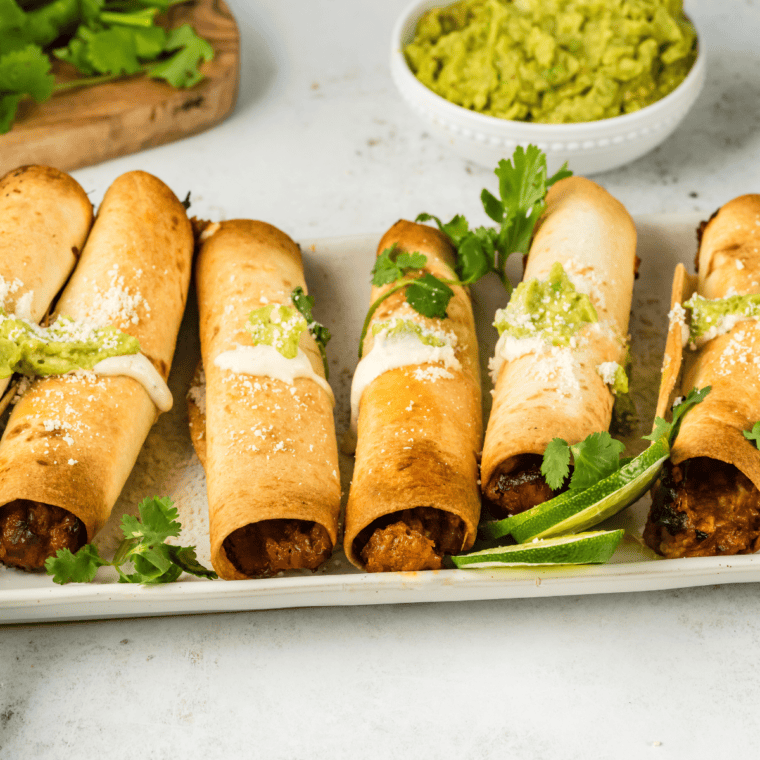 Crispy Air Fryer Pulled Pork Taquitos filled with tender pulled pork, golden-brown and delicious, served with a side of dipping sauce.