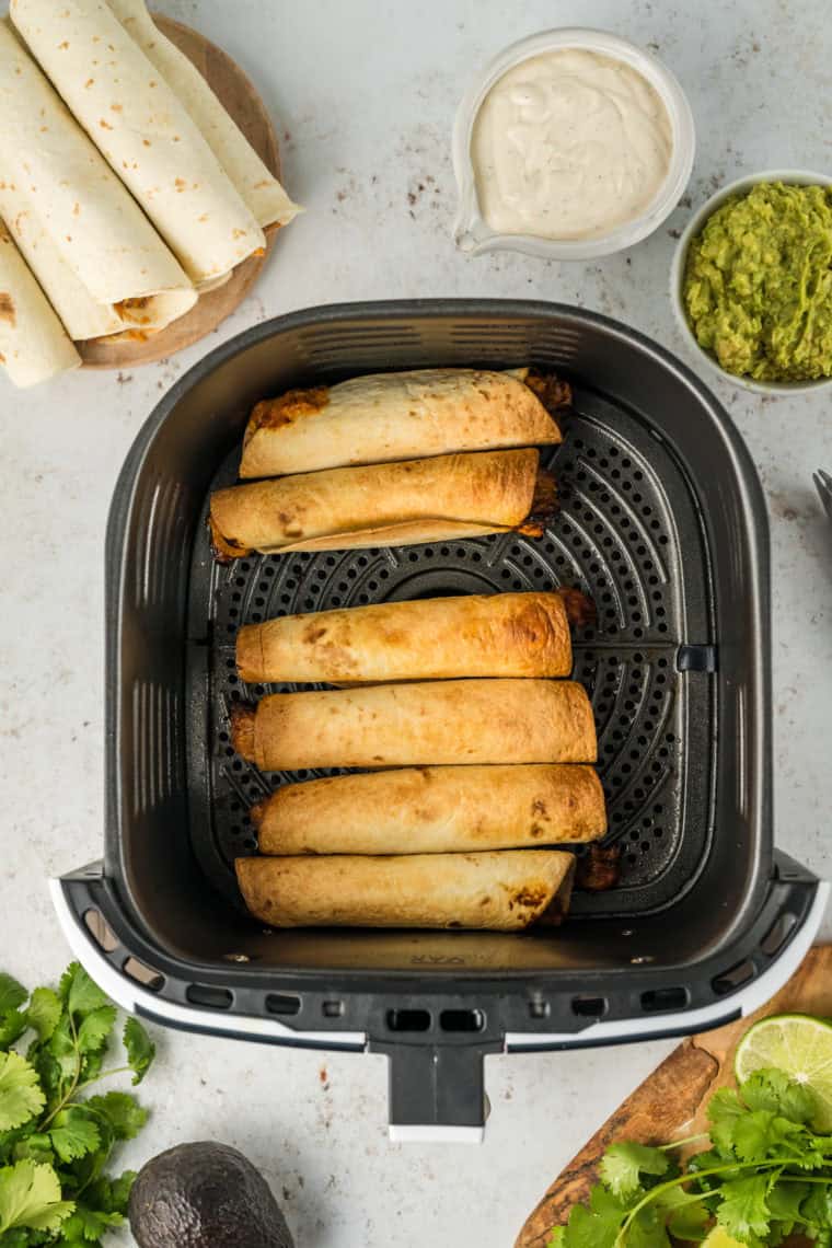 Preheat air fryer, spray taquitos with oil, and cook at 400°F for 6-8 minutes, flipping halfway.