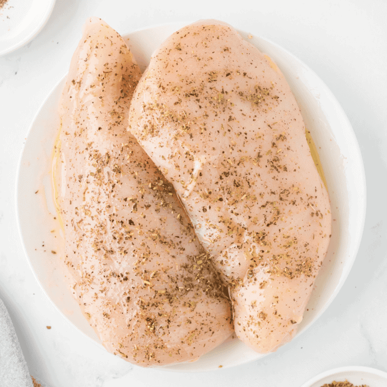 Two uncooked seasoned chicken breasts