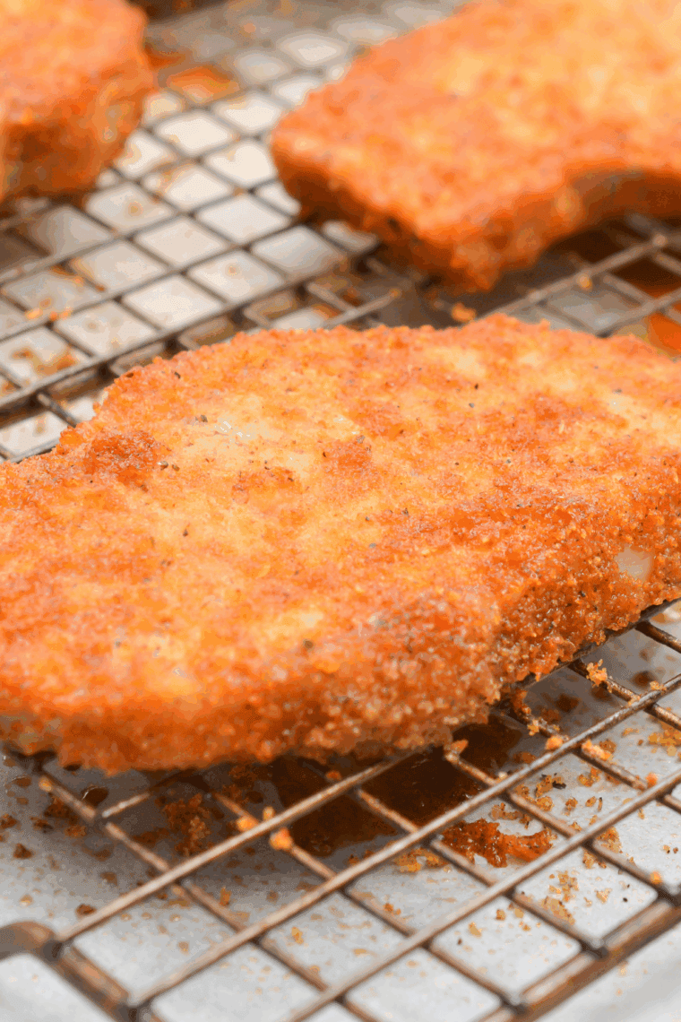 Golden, breaded Bob Evans-style pork chops served on a plate with garnish.