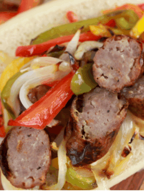 Golden Corral sausage and peppers copycat with browned sausage slices, sautéed red and green peppers, and onions in a skillet.