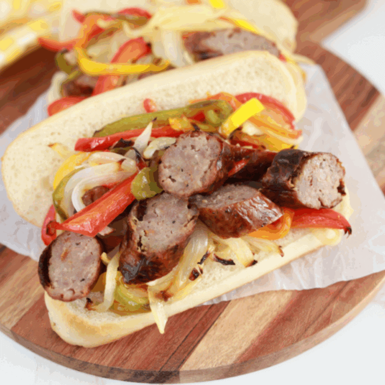 Golden Corral Sausage and Peppers copycat with browned sausage slices and sautéed peppers and onions in a serving dish.