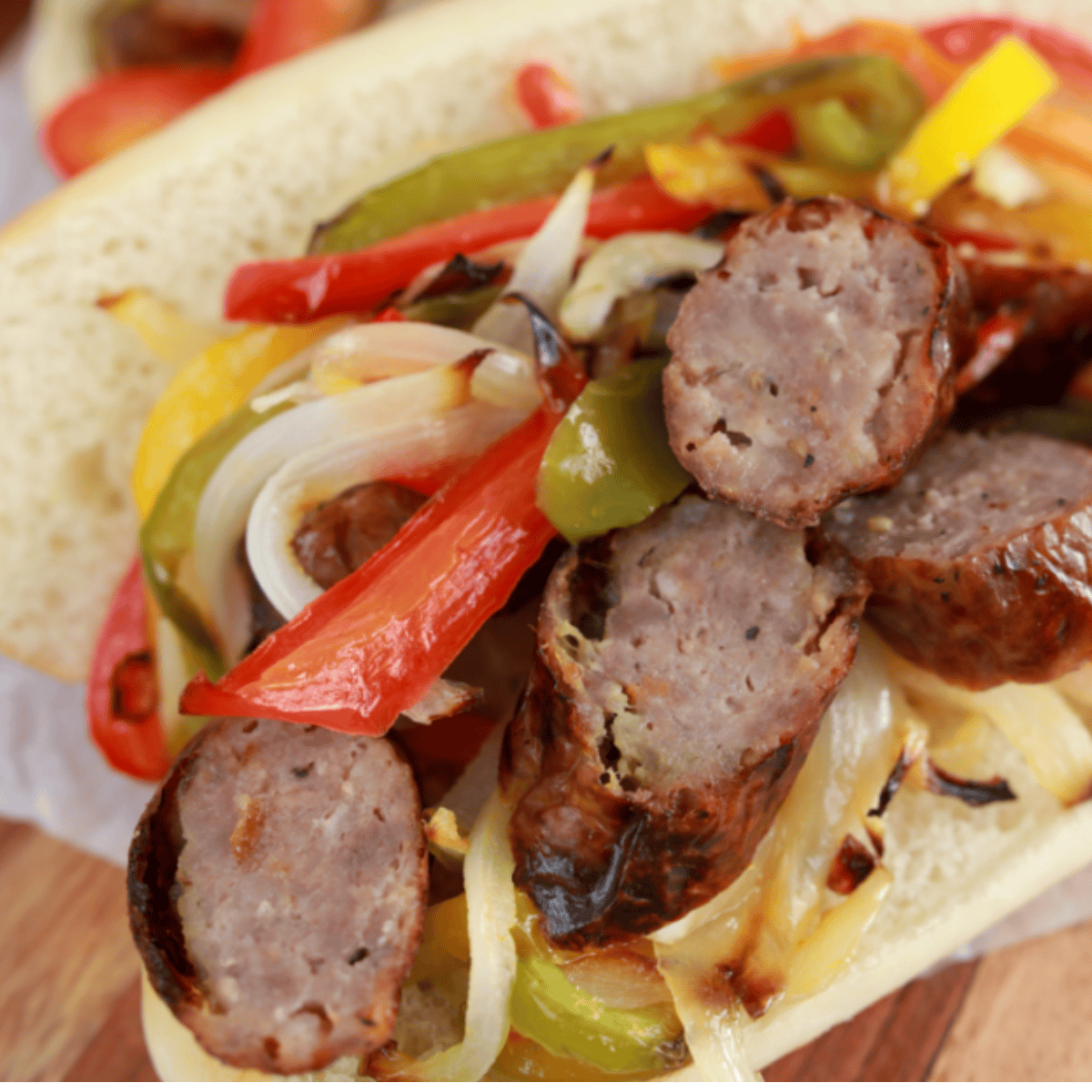 Golden Corral sausage and peppers copycat with browned sausage slices, sautéed red and green peppers, and onions in a skillet.
