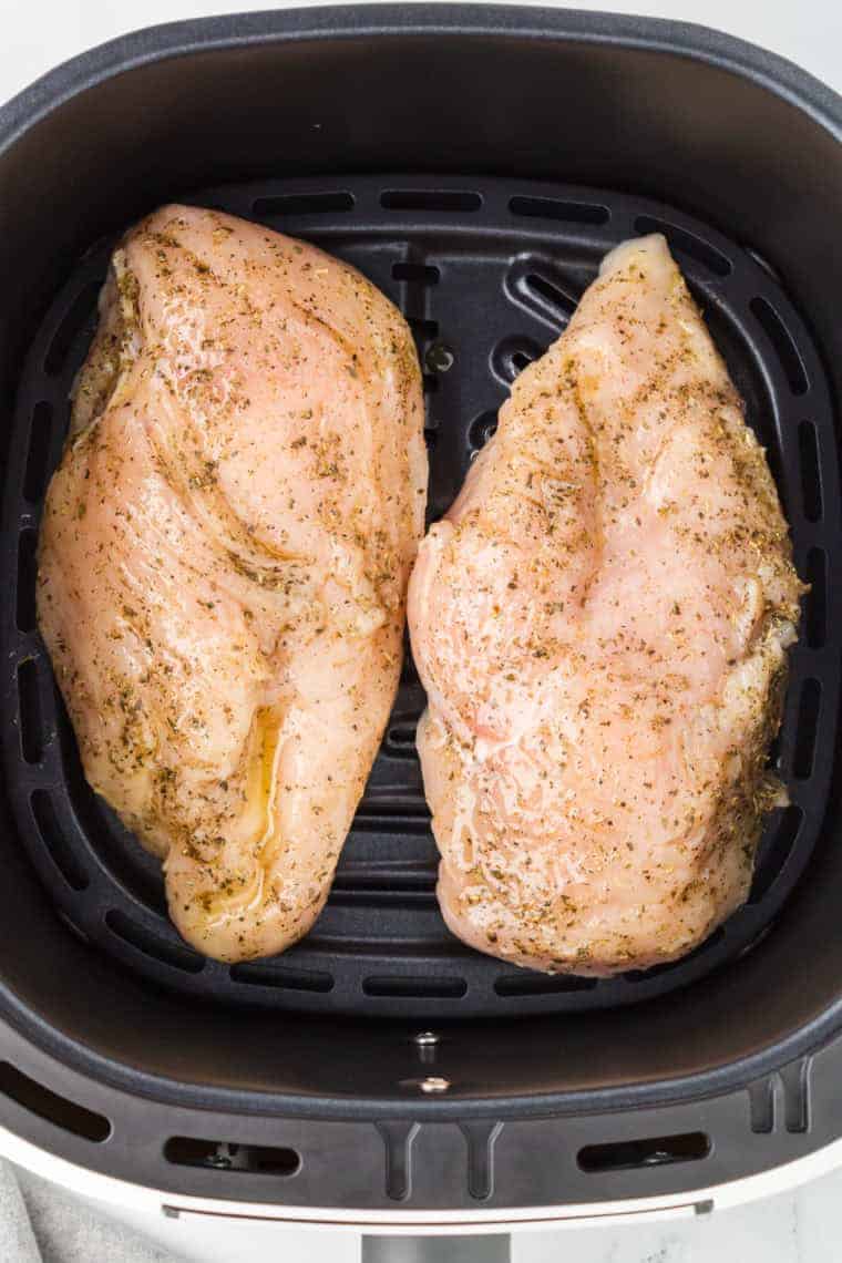 Cooking the chicken in the air fryer basket.