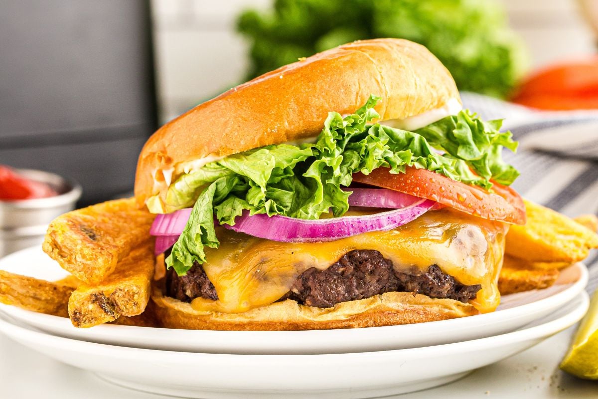 A juicy air fryer cheeseburger on a plate.