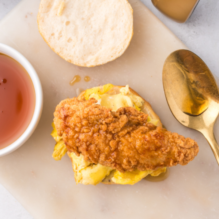 Assembling the chicken biscuit sandwich on a cutting board.