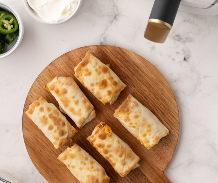 Finished Jalapeno Popper Egg Rolls: A plate of freshly cooked jalapeno popper egg rolls, showing their crispy exterior and melted cheesy interior.