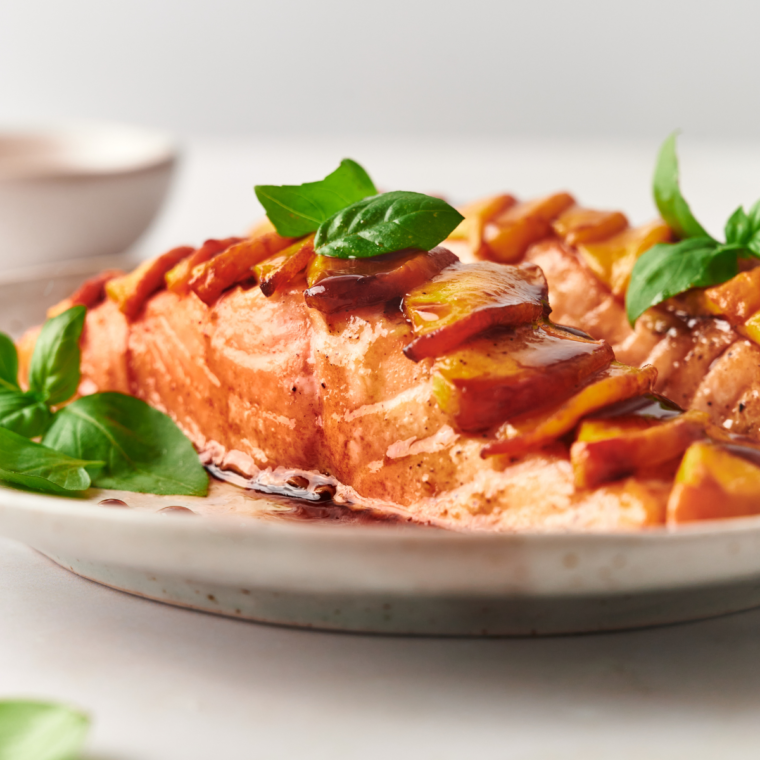 side view: air fryer frozen salmon with peaches, sauce, and fresh herbs on top