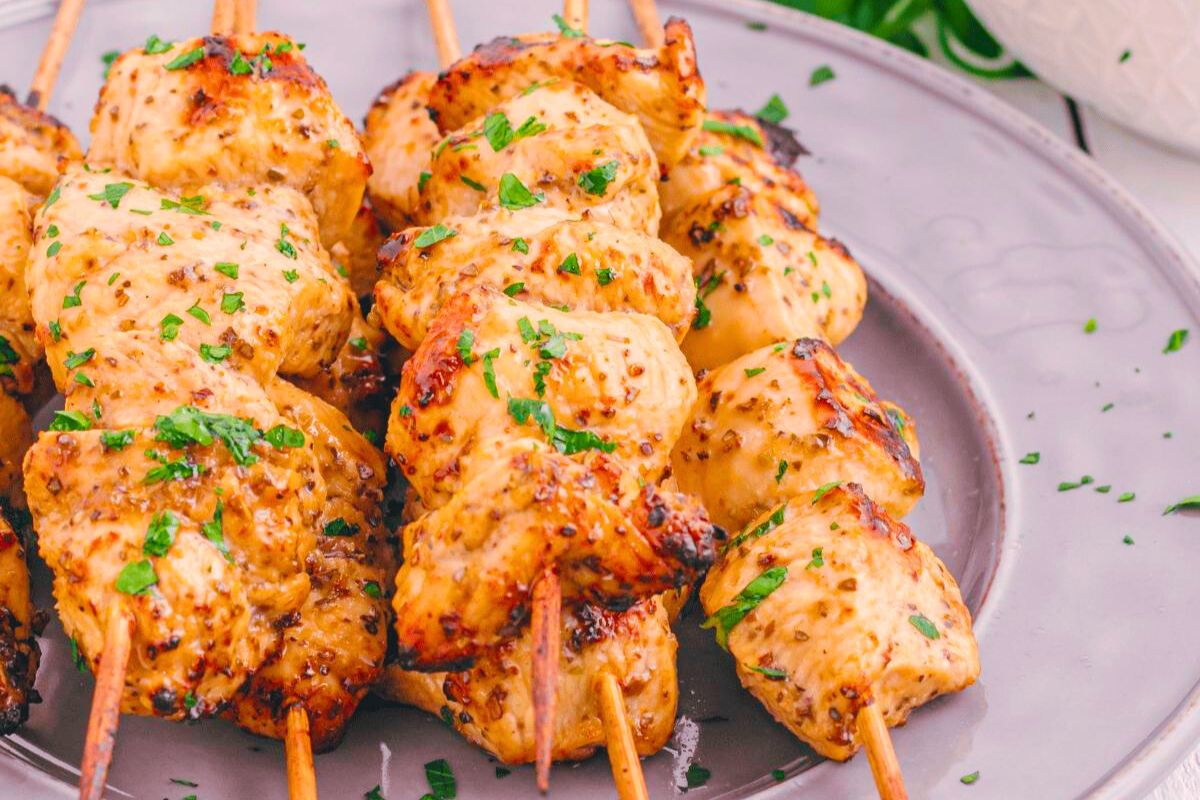 Greek chicken skewers on a plate.