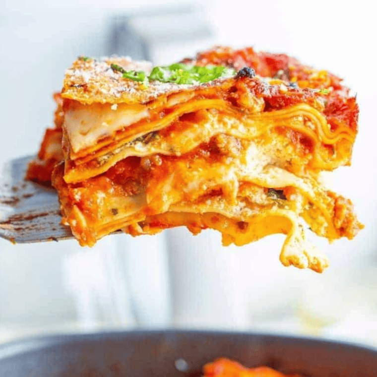 side view: a serving spoon lifting a slice of air fryer lasagna