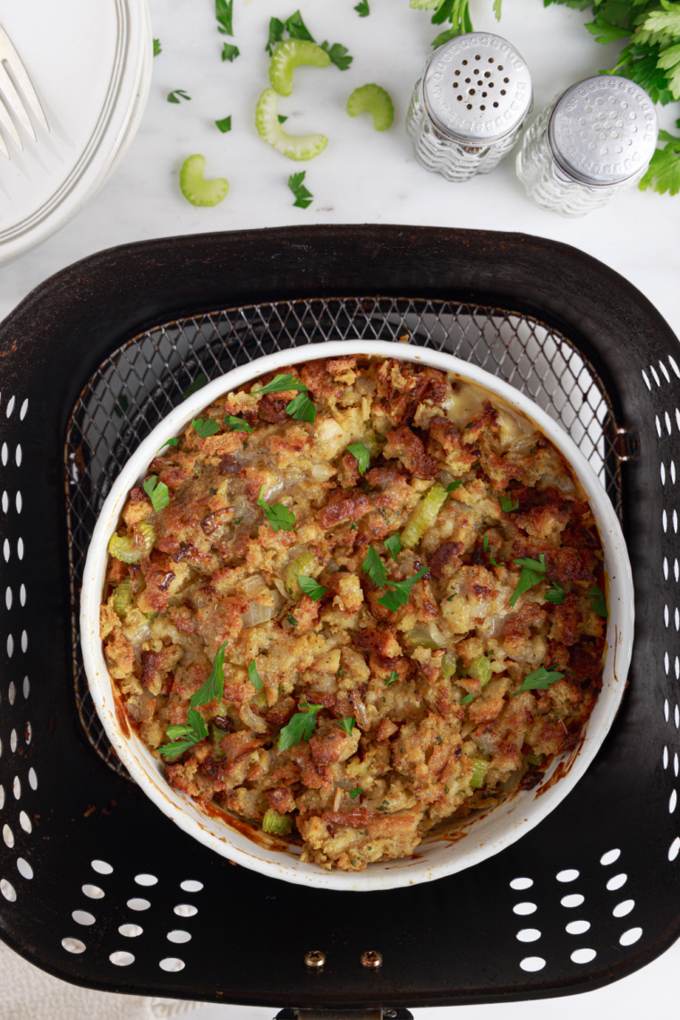 Serving spoon scooping out a portion of chicken and stuffing casserole from a dish.