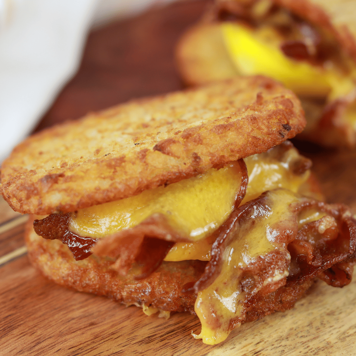 closeup side view: air fryer hash brown patties used as bread for bacon, egg, cheese sandwiches