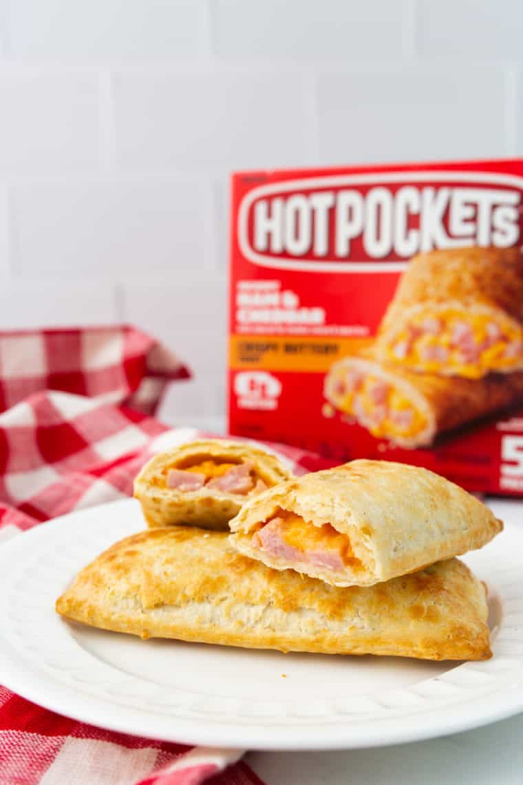 three air fryer hot pockets on a white plate with a box of hot pockets in the background