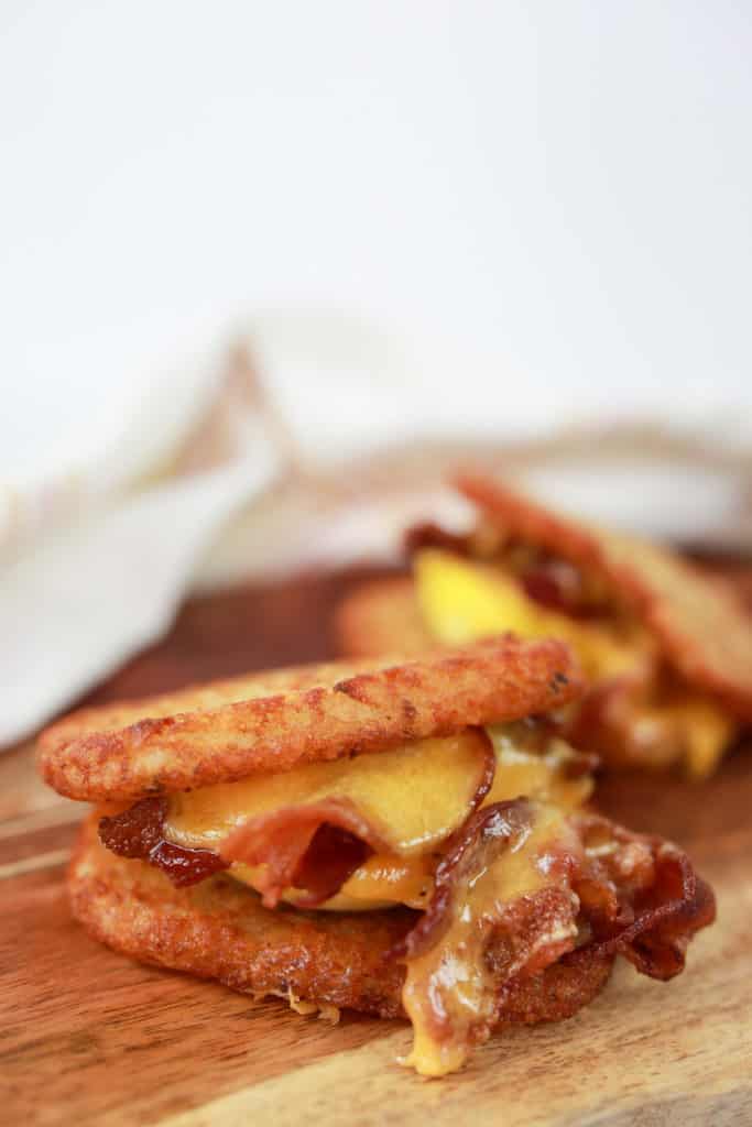 side view closeup: air fryer trader joe's hashbrowns used as bread in bacon, egg, and cheese sandwich