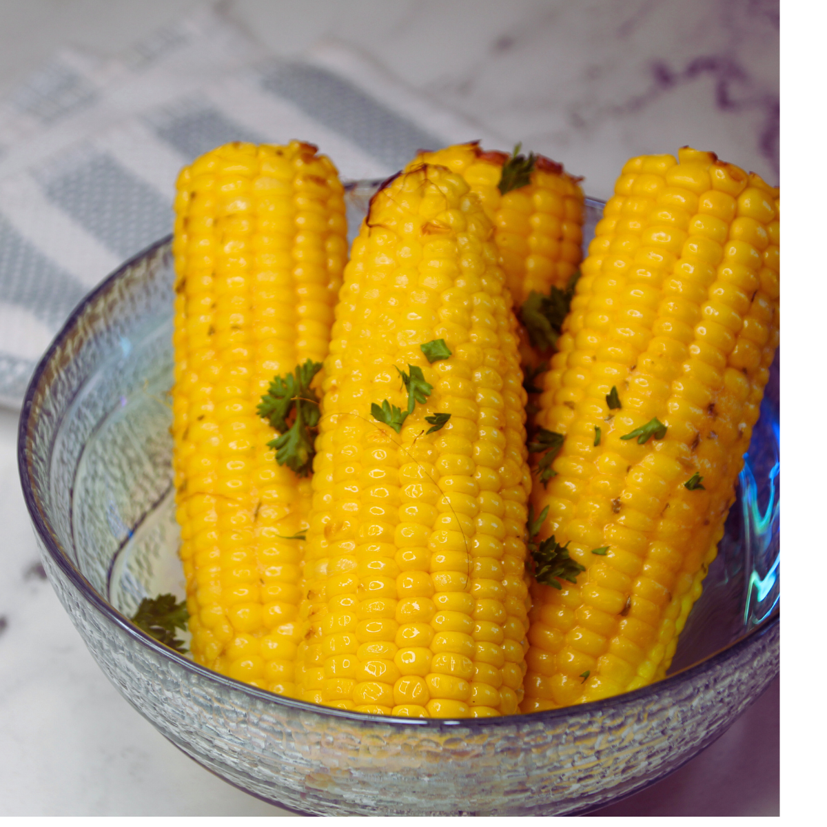 closeup: cooked corn on the cob in a glass bowl