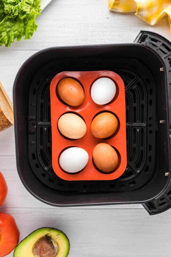 overhead: hard boiled eggs in the air fryer basket in a silicone mold