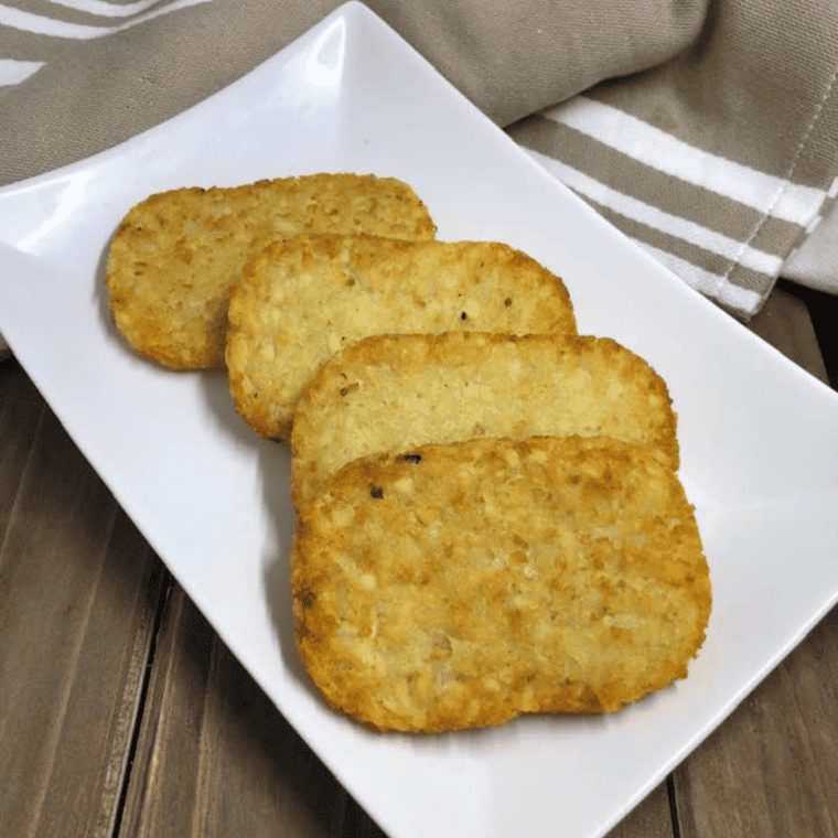 closeup: four trader joe's hash browns from air fryer on a white plate
