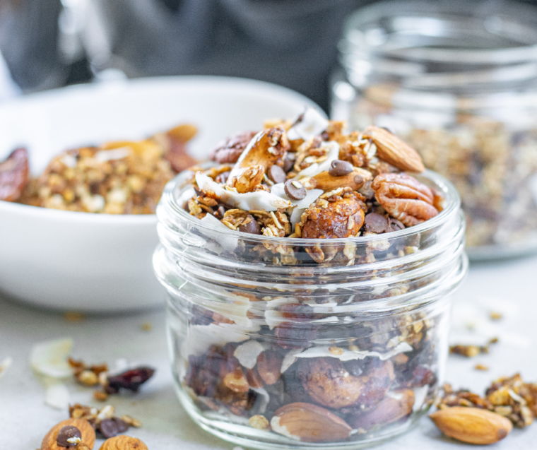 Muesli in a large mason jar with sprinkles of Muesli in the background