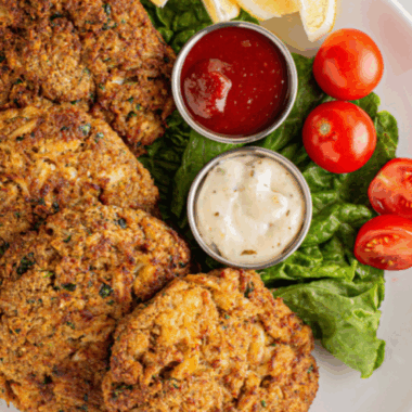 Bowl of homemade Outback Steakhouse remoulade sauce with spoon, surrounded by dipping ingredients.