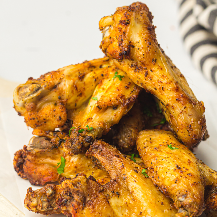 Plate of seasoned steakhouse wings on a plate stacked