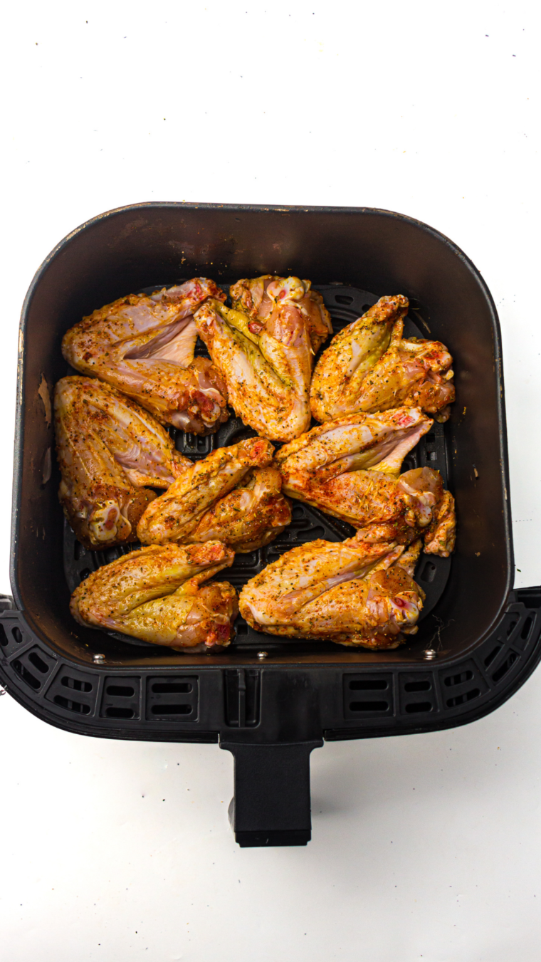 uncooked coated steakhouse chicken wings in air fryer basket