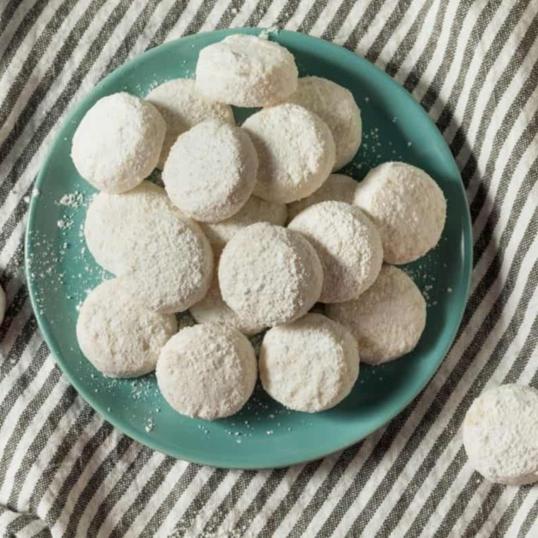 Plate of snowball cookies on green/blue pate.