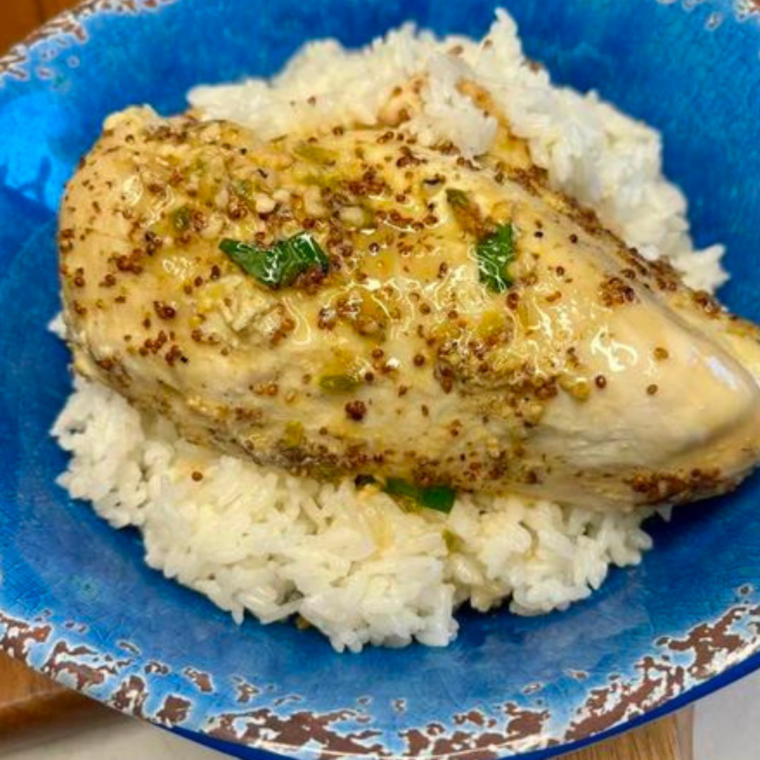 Plate of Ninja Foodi Possible Cooker Pro Garlic Chicken on a bed of white rice, in a blue bowl.