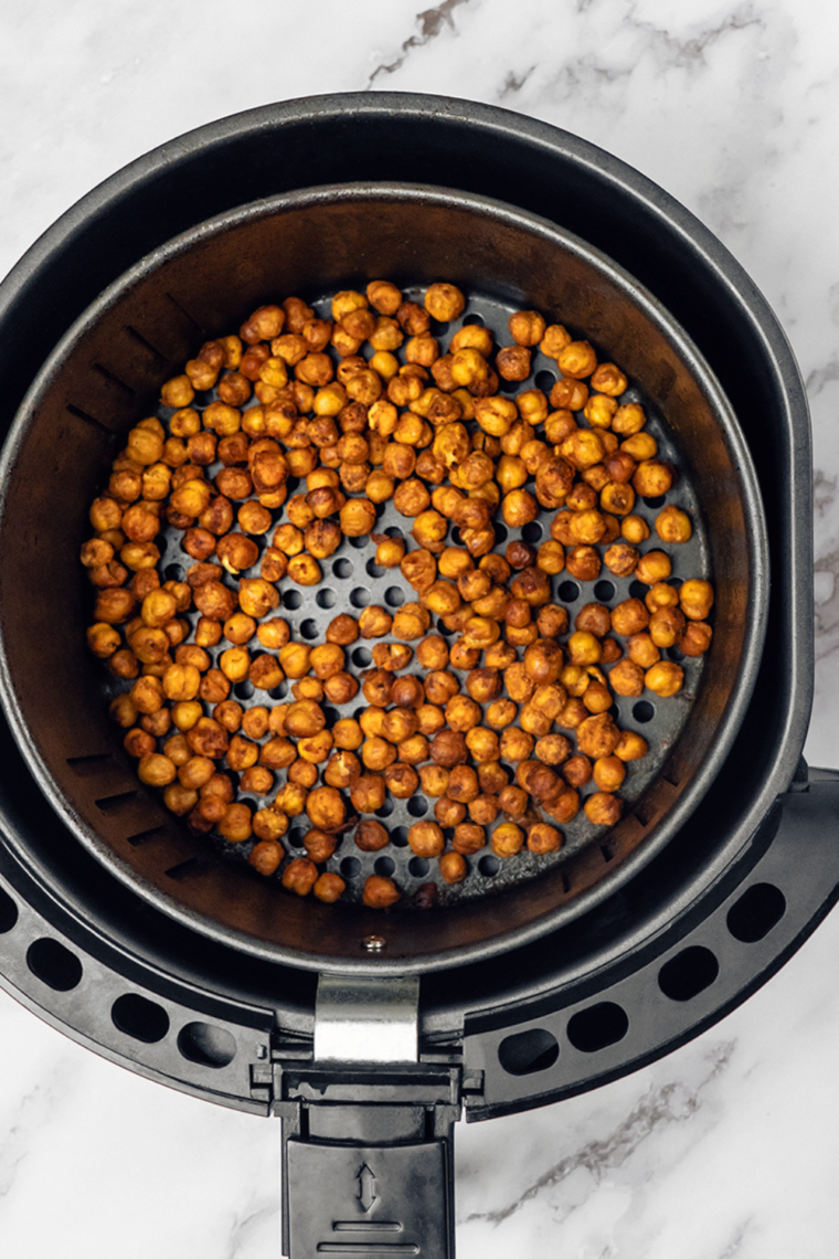 Chickpeas in the air fryer basket, arranged in a single layer