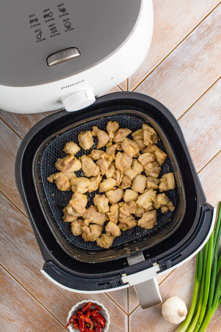 Cooking chicken bites in the air fryer, halfway through the process.