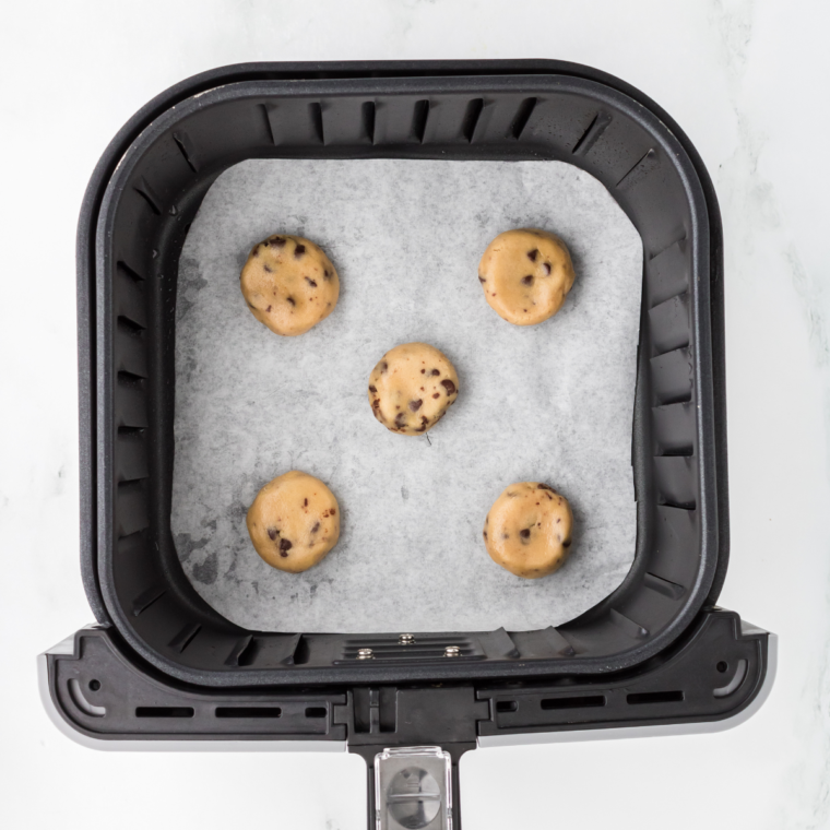 Place parchment down in the air fryer basket and set the cookie dough on top.