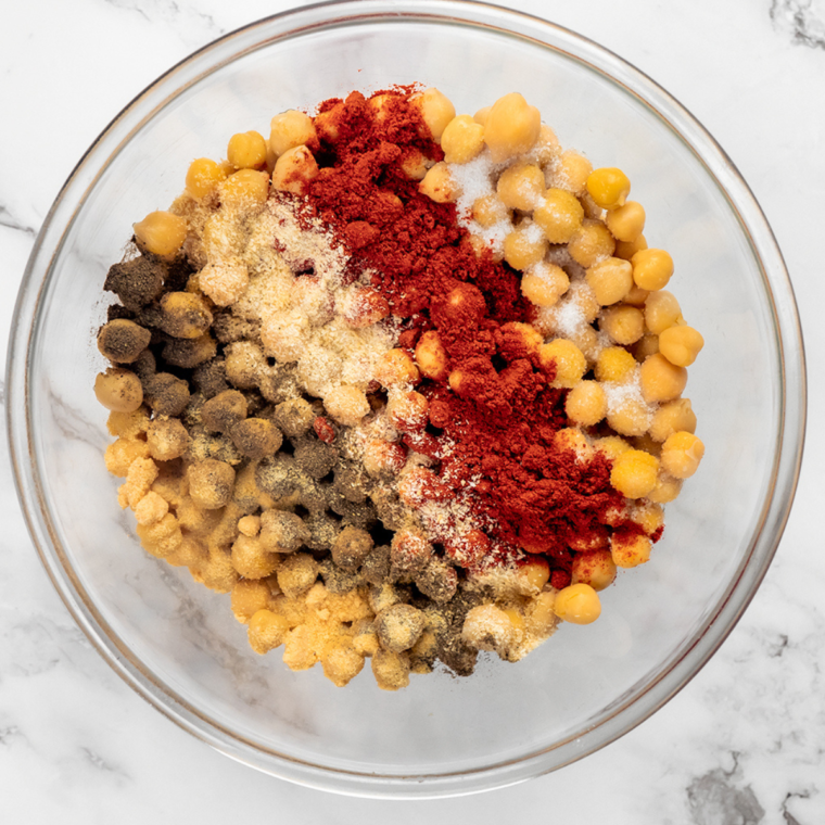 Seasoning mix of garlic powder, onion powder, paprika, cumin, salt, and pepper on a cutting board