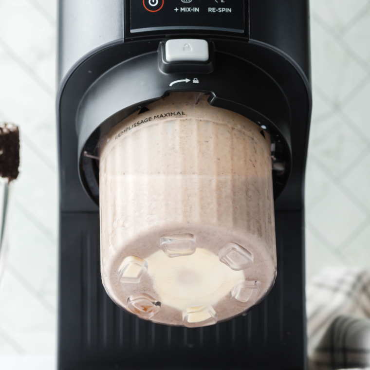 Stirring the ice cream and milk mixture in the pint container until smooth and well combined for the Sonic Oreo Chocolate Shake.